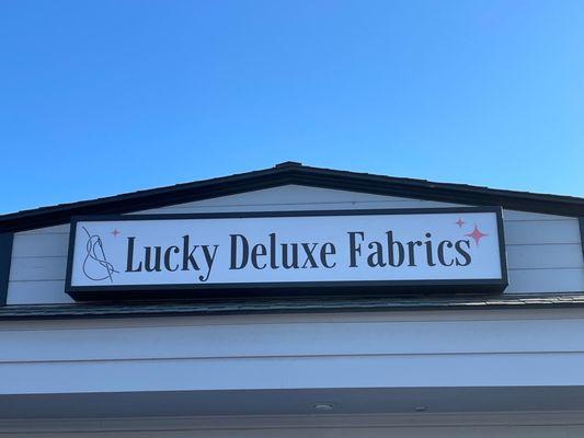 Store front sign reading Lucky DeLuxe Fabrics