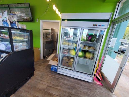 Fridge with fresh fruits. Watermelon, banana, macaroons.