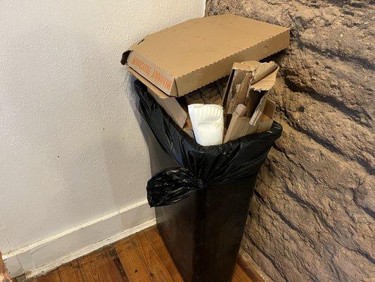 Overflowing trash, cans in the dining room.