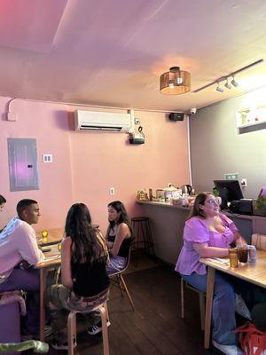 Small interior with about five tables and one bar stool seating