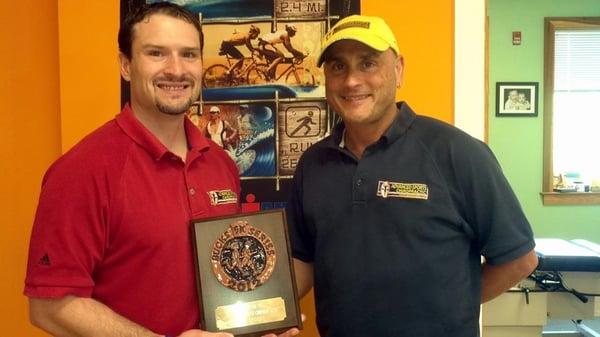 Dr. Derek and Dr. Johnny, with Advanced Sports Chiropractic's award for being the Title Sponsor of the Bucks 5k Series.