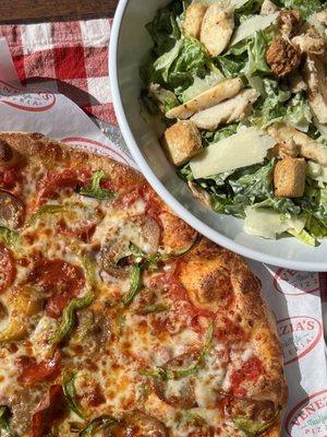 Large Chicken Cesear Salad with fresh lettuce and buttery croutons next to a hot and fresh large pepperoni, sausage, and pepper pizza!