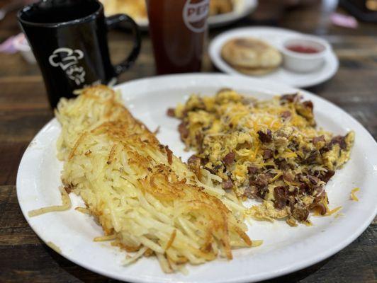 Meat lovers scramble with hashbrowns, English muffin, and jam.