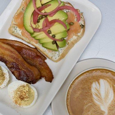 Salmon & avocado toast breakfast special with a latte.