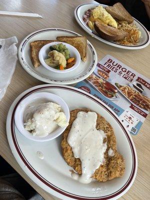 Country fried steak and gravy with mashed potatoes and vegetables