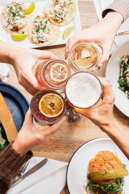 People clinking cocktails at happy hour.