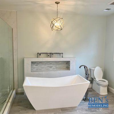 a remodeled bathroom, stand-alone tub , comfort height toilet, brushed nickel finish