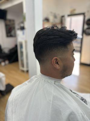 Mid fade with a comb back hairstyle