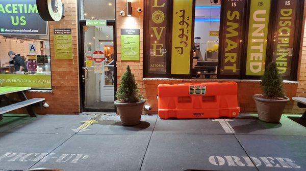 Outside the business. See the floor markings for ordering and pick up