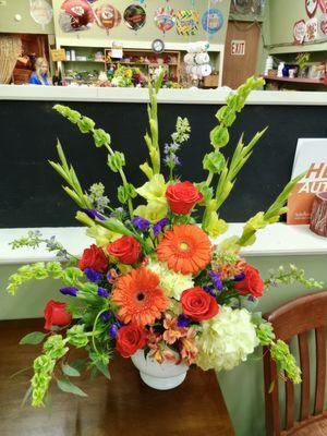 Large, fun colorful mix with glads, bells, gerberas, roses, hydrangeas, iris and alstromeria.