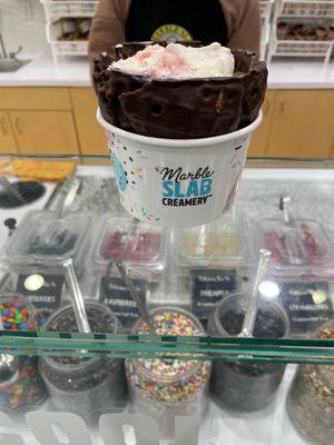 Sweet cream with strawberries in chocolate dipped waffle bowl