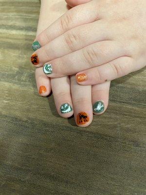 Sweet little hands with a Halloween manicure.