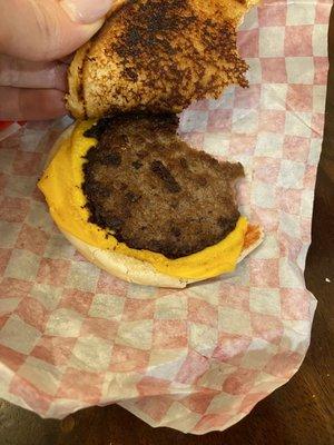 Cold partially burnt cheeseburger