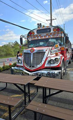 Front of the Taco Bar Bus with some picnic tables to sit down and munch-out.