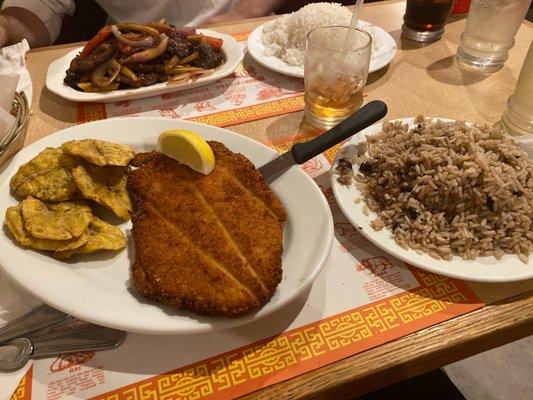 Breaded chicken with tostones, black beans and rice