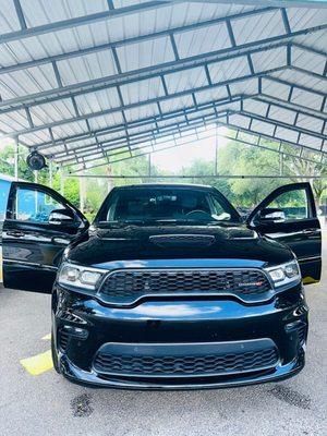 Shiny black car with a happy customer hand wax