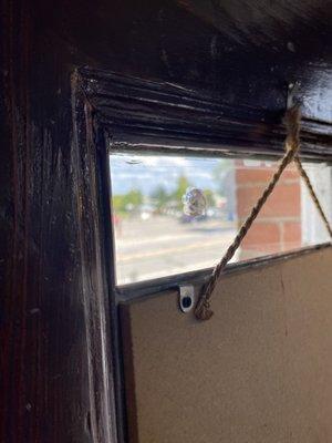 Original window glass with damage (left side of the rope) from a bank robbery