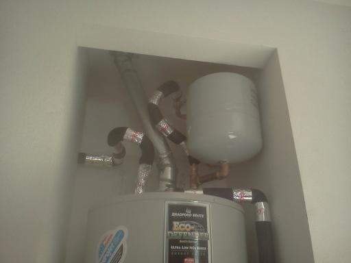 Thermal expansion tank installed at top of water heater.