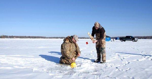 Hearty (fool hardy) Minnesotans ice fishing on a frozen lake.