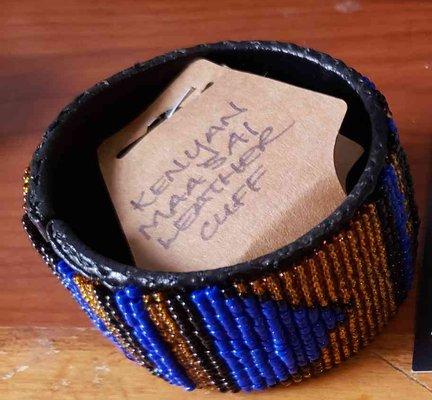 Maasai beaded cuff in blue, black, and orange, representing divine energy from the sky, the struggles of the people, and hospitality.