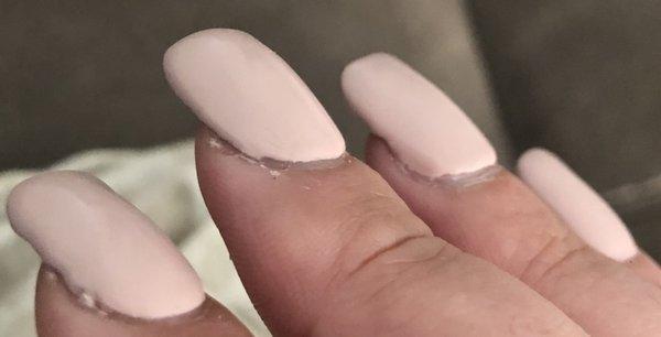 Cuticles weren't pushed back. Uneven acrylic. Sloppy nail polish