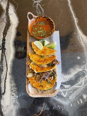 Come Try Our Mouthwatering Beef Birria Tacos topped with Oaxaca Cheese, Cilantro and Onions accompanied with a side of Consume and Limes