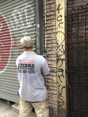 Our gate tech working to repair an existing store front gate