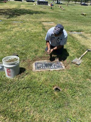 He's doing the surrounding of the headstone.