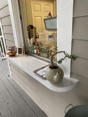 Order window on back with outdoor porch dining, overlooking the gardens.