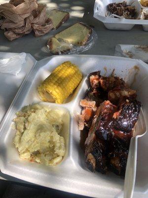 Buttered corn, potato salad, ribs, and pound cake