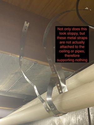 Not only does this look sloppy, but these metal straps are not attached to the ceiling or pipes, therefore supporting nothing.