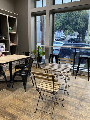 Interior with small and large tables, and bar seating at the window