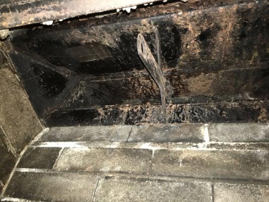 An example of water dripping through a chimney and rusting the damper in the fireplace.