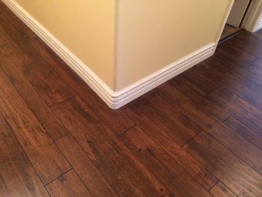 Multiple width Laminate flooring with   top set upgraded  wall base with  matching custom wall base corners