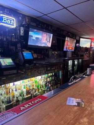 Bar with movies and selection of drinks.