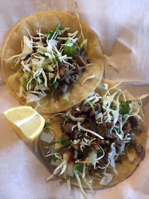 2 carne asada (beef) tacos. corn tortillas, cabbage, onion, and cilantro. Served with spicy and delicious red and green sauces. Total: $2.45