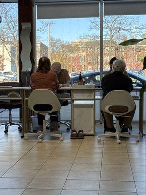 Two customers receiving manicures.