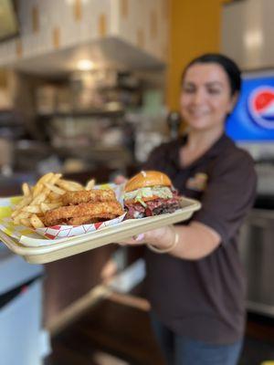 Angela presenting the All American Double with Pastrami and Half & Half (fries/ onion rings)