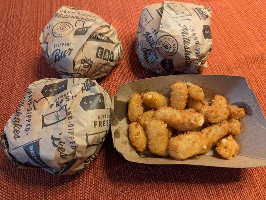 Three unmarked burgers and large side of cheese curds. CLASSIC, RODEO BURGER RODEO BURGER FULL SIZE FRIED CHEESE CURDS