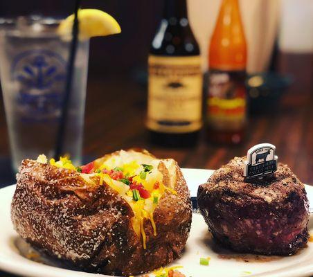 A loaded baked potato with a tender steak