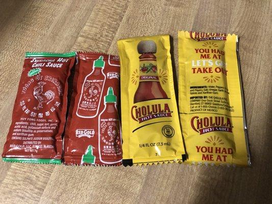 They have hot sauce packets for takeout. Not as many choices as the hot sauces on the shelf inside.