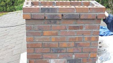 Chimney being rebuilt after a tree fell on it.