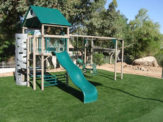 Play area with synthetic turf and safety mat