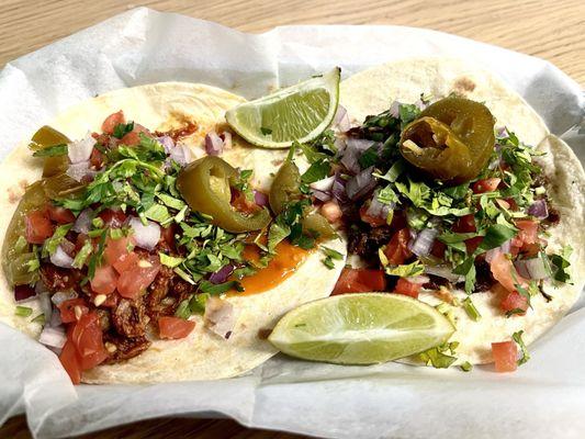 Barbacoa Taco on left; Steak Taco on right