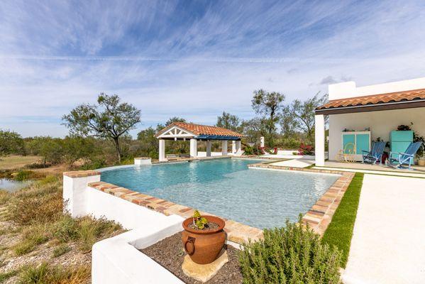 This Spanish styled pool perfectly fits the home aesthetic