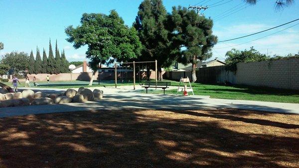 swings w basketball court in background