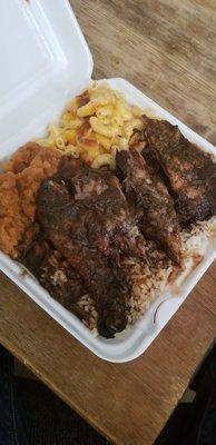 Small jerk chicken platter with rice, mac & cheese, and candied yams