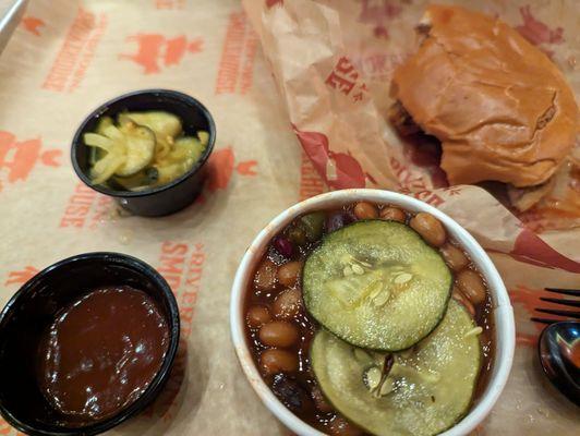 Barbecue sandwich, BBQ beans, pickles, and BBQ sauce