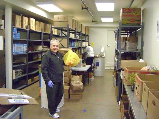 Jose ready with a bag of good grub in the Food Pantry.