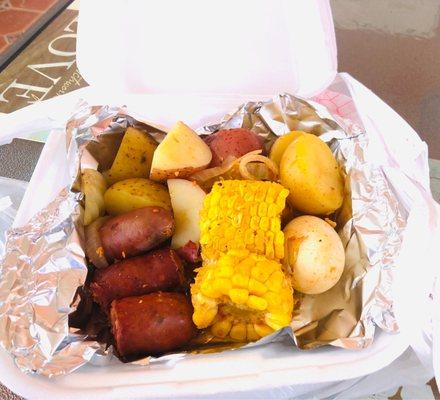 Corn.  Taters.  Sausage.  Egg. The seasoning was odd for a seafood joint. Tomato-based. Old Bay would be better.